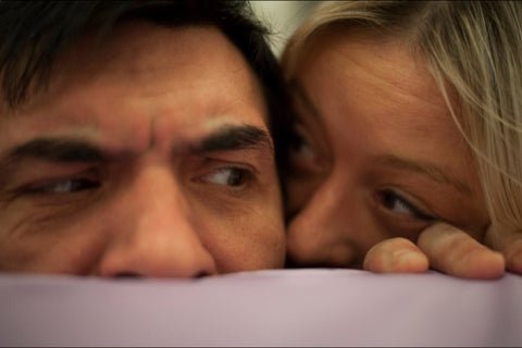 Two people peeking playfully over a counter