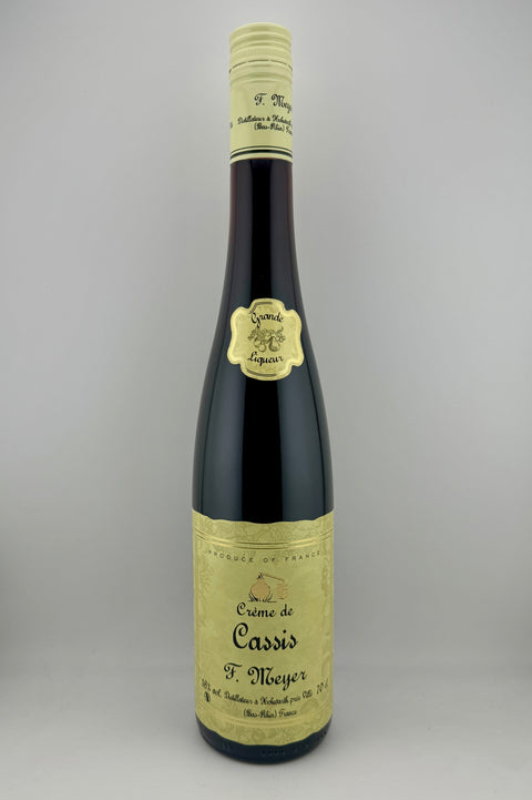 A bottle of Creme de Cassis, Distillerie Meyer with a yellow label and a cap on top.