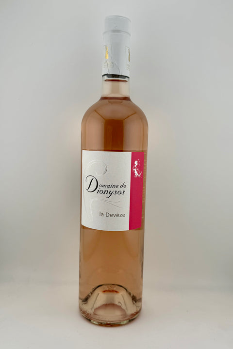 A bottle of Devéze, Domaine Dionysos, AOC Côtes du Rhône, 2023 wine with a pink label and a clear, pale pink wine visible in the bottle.