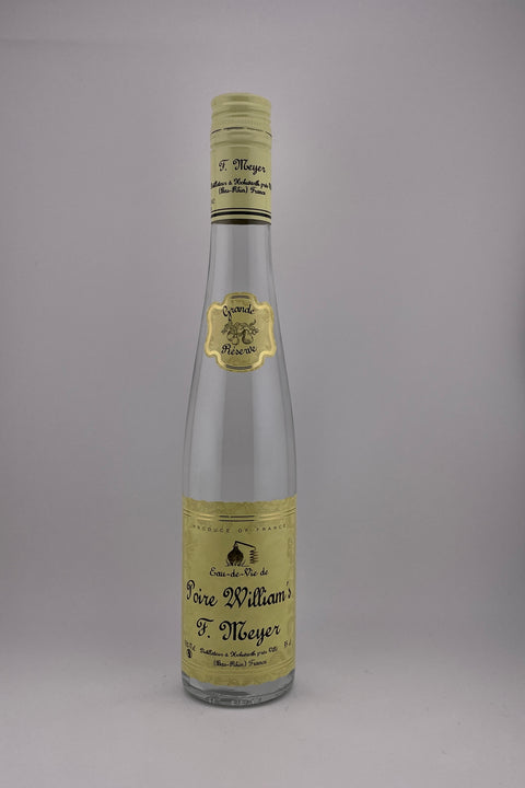 A bottle of Poire William liqueur by Distillerie Meyer, with a clear glass body and a label that includes the brand name and the word 'Liqueur'. The bottle cap is off, and the liquid inside appears to be a pale yellow color.