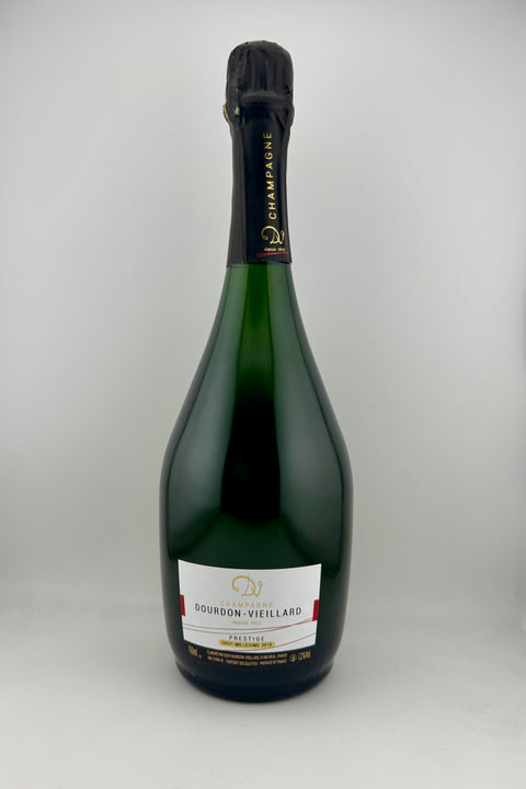 A bottle of Dourdon Vieillard Champagne with a gold foil cap on a plain background.
